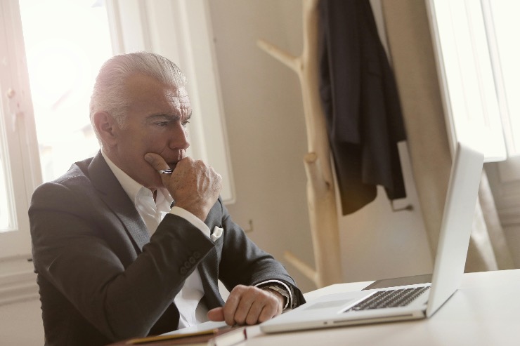 uomo elegante pensieroso al pc 