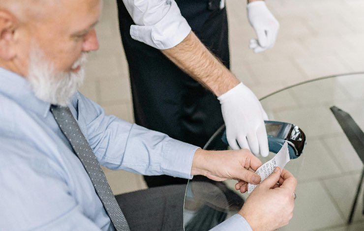 signore che controlla lo scontrino del pos 