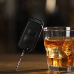 La chiave dell'auto appoggiata su un bicchiere di grappa