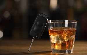 La chiave dell'auto appoggiata su un bicchiere di grappa