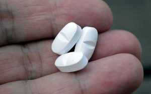 compresse, farmaci in mano