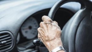 Mano di un'anziana al volante