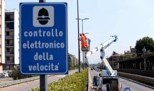 Segnale controllo elettronico della velocità e tecnici che installano i nuovi autovelox