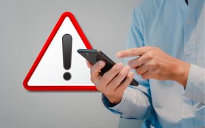 Uomo che indica lo smartphone e segnale di attenzione, pericolo