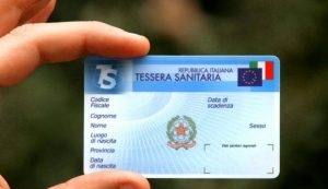 Persona che tiene in mano una tessera sanitaria