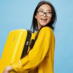 Ragazza felice con un bagaglio in mano pronta a prendere un aereo