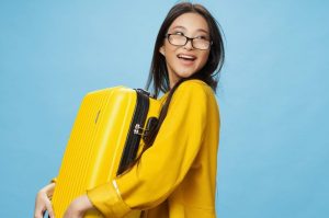 Ragazza felice con un bagaglio in mano pronta a prendere un aereo