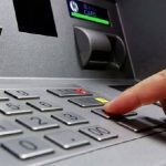 Uomo che preme un tasto del bancomat