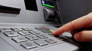 Uomo che preme un tasto del bancomat