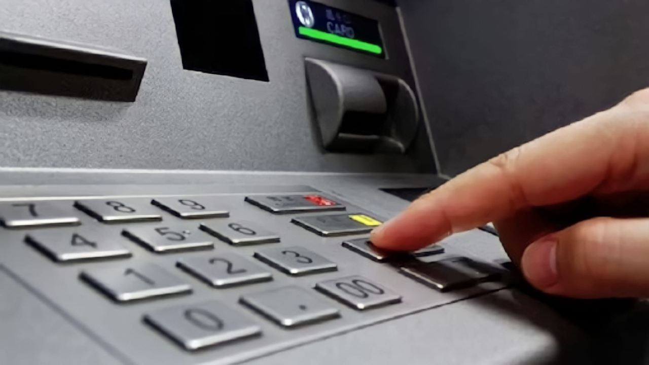 Uomo che preme un tasto del bancomat
