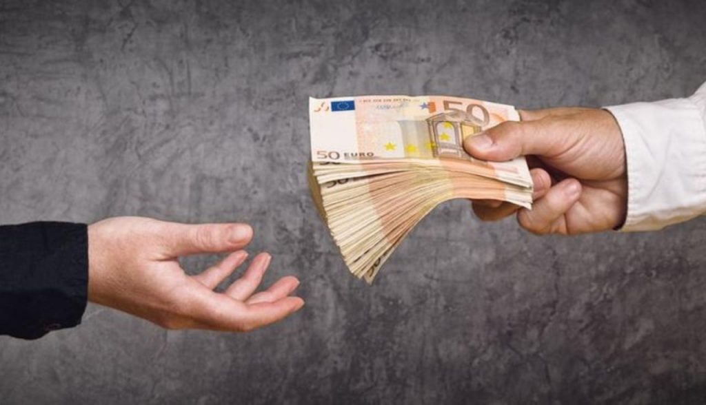 Datore di lavoro che da una mazzetta di banconote alla dipendente
