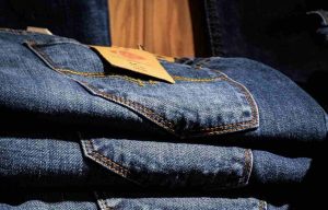 Jeans piegati con etichetta su scaffale di un negozio