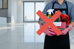 Uomo con secchio, detersivi in mano e una X. Pavimento pulito sullo sfondo