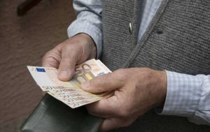 over 80 con in mano banconote euro: pensionato