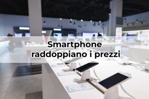 Negozio di elettronica con smartphone esposti e scritta "smartphone raddoppiano i prezzi"