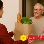 Uomo anziano che riceve la spesa a domicilio e logo Conad
