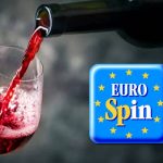 Bottiglia versata su calice di vino e logo Eurospin