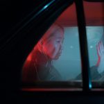 donna con la mano sul finestrino dell'auto