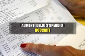 Scritta: "Bocciati gli aumenti in busta paga" su sfondo di una busta paga