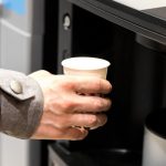 Dipendente che prende un caffè alla macchinetta