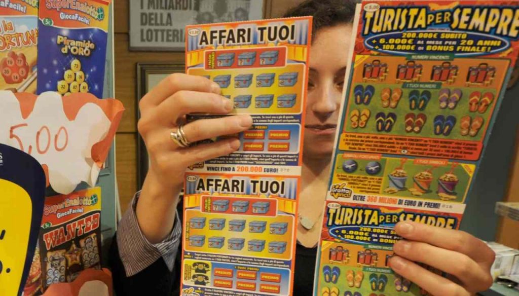 Tabaccaia con pile di gratta e vinci in mano