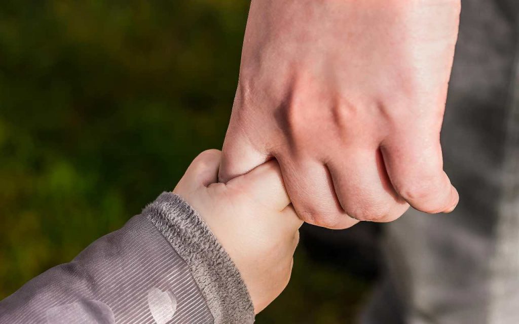 mano del papà che stringe la mano del figlio