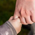 mano del papà che stringe la mano del figlio