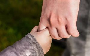 mano del papà che stringe la mano del figlio