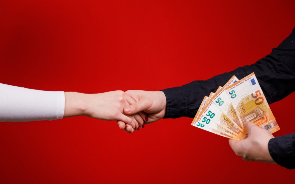 Due persone che si stringono la mano dopo un pagamento in contanti
