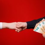 Due persone che si stringono la mano dopo un pagamento in contanti