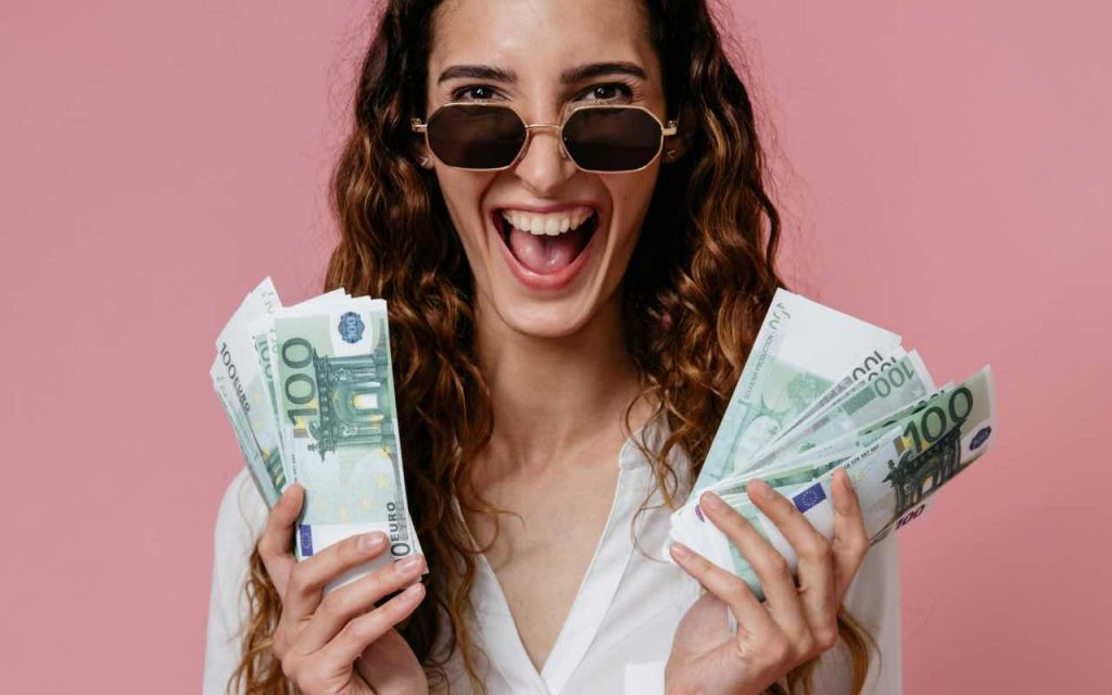 ragazza entusiasta con centinaia di euro in mano