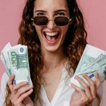 ragazza entusiasta con centinaia di euro in mano