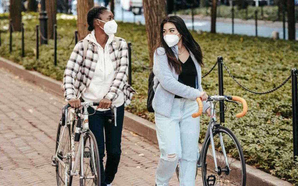ragazzi in bicicletta con le mascherine