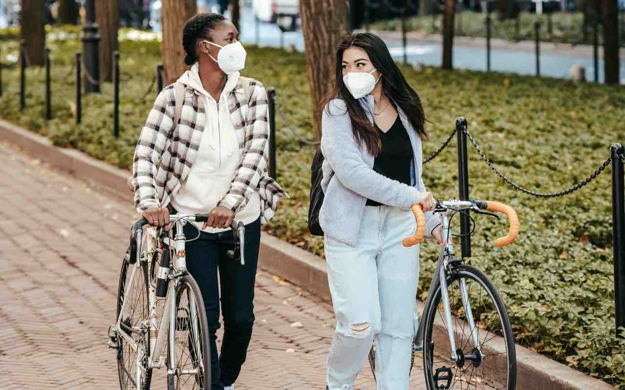 ragazzi in bicicletta con le mascherine