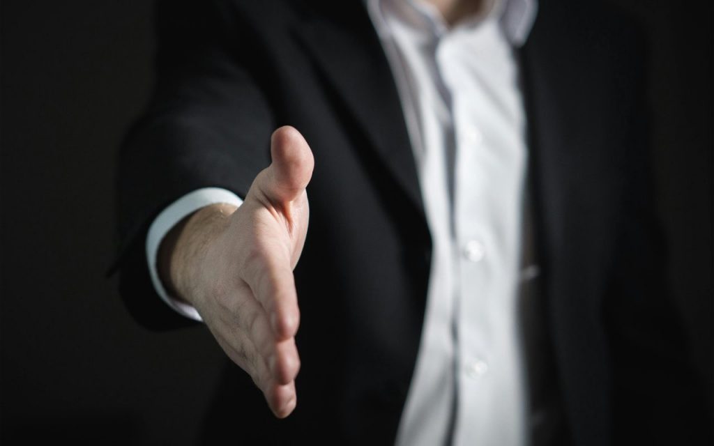 persona che allunga la mano da stringere