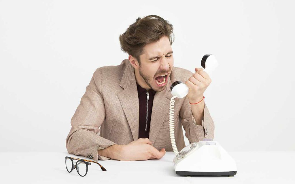 uomo che grida al telefono