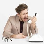 uomo che grida al telefono