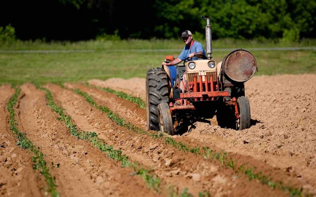 uomo sul trattore in un campo da arare
