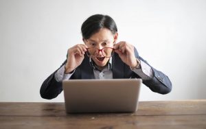 uomo stupito di fronte al pc