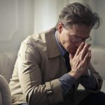 uomo che riflette con la testa tra le mani