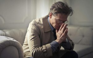 uomo che riflette con la testa tra le mani