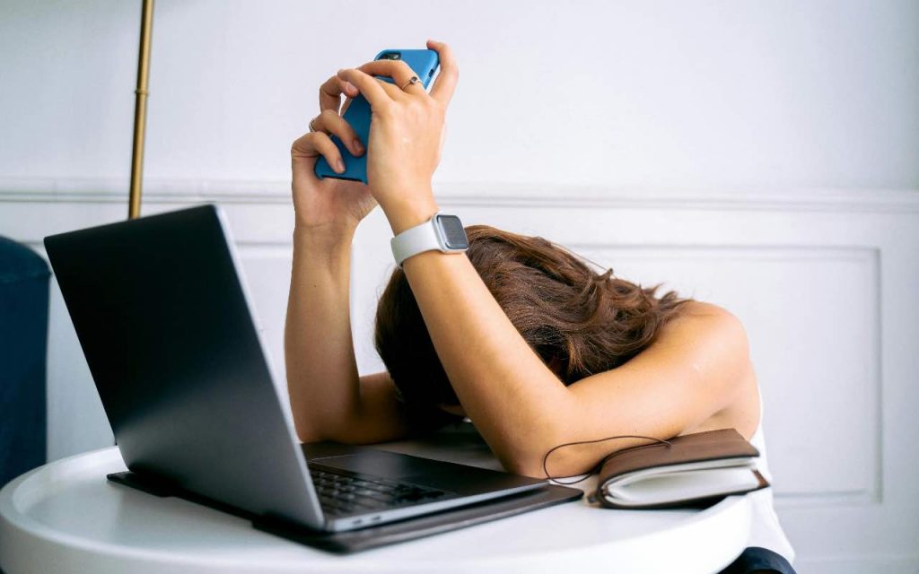 donna disperata con pc e smartphone