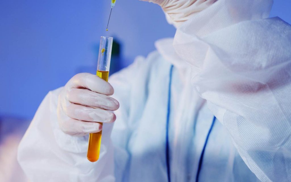 medico con una fiala in mano e una siringa