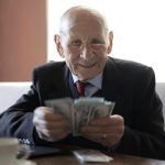 pensionato felice che conta i soldi