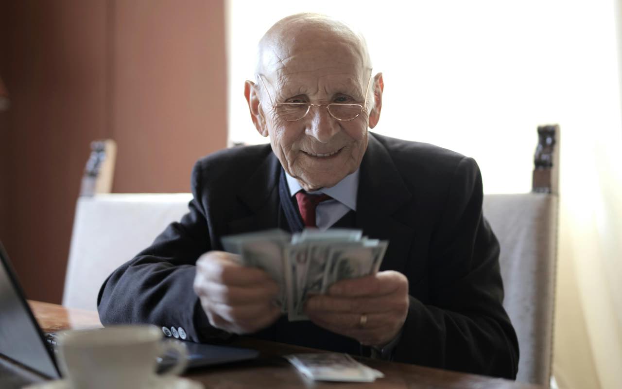 pensionato felice che conta i soldi