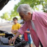 anziano che controlla l'auto