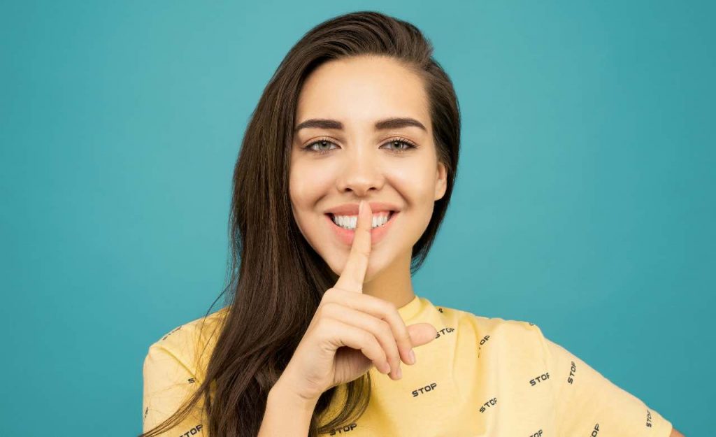ragazza che fa il segno del silenzio
