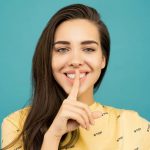 ragazza che fa il segno del silenzio