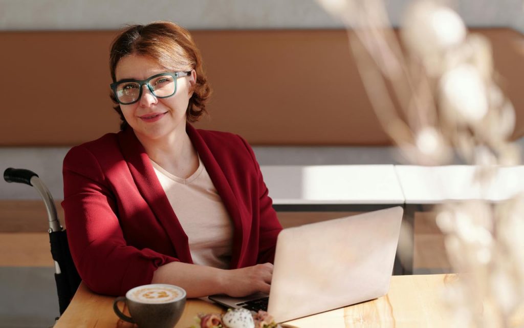 donna su sedia a rotelle di fronte al pc