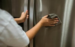 mano che pulisce il frigo